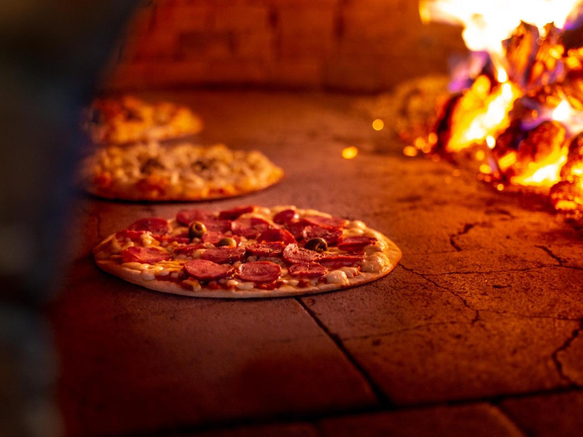 Ocean Palace All Inclusive Premium Natal Exterior foto Pizza being cooked in a wood-fired oven